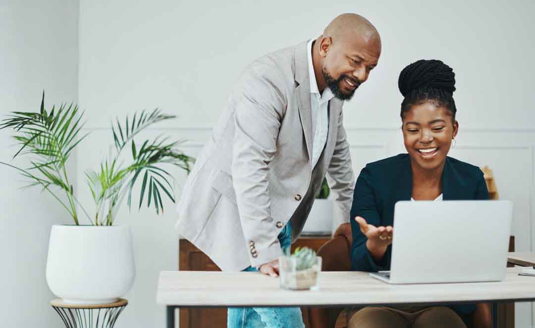 Shot of a businessman and businesswoman using a laptop together in a modern office Shot of a businessman and businesswoman using a laptop together in a modern office
